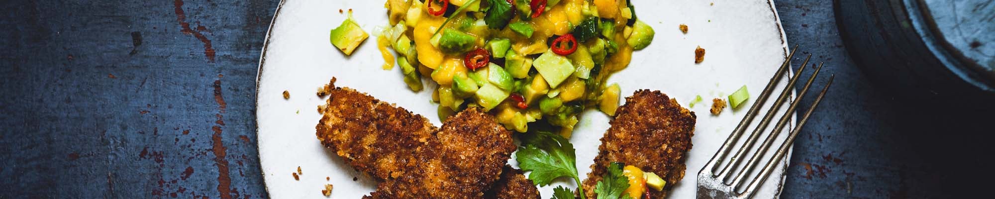 Brezel-Stäbchen auf einem Teller mit Mango und Avocado Tartar